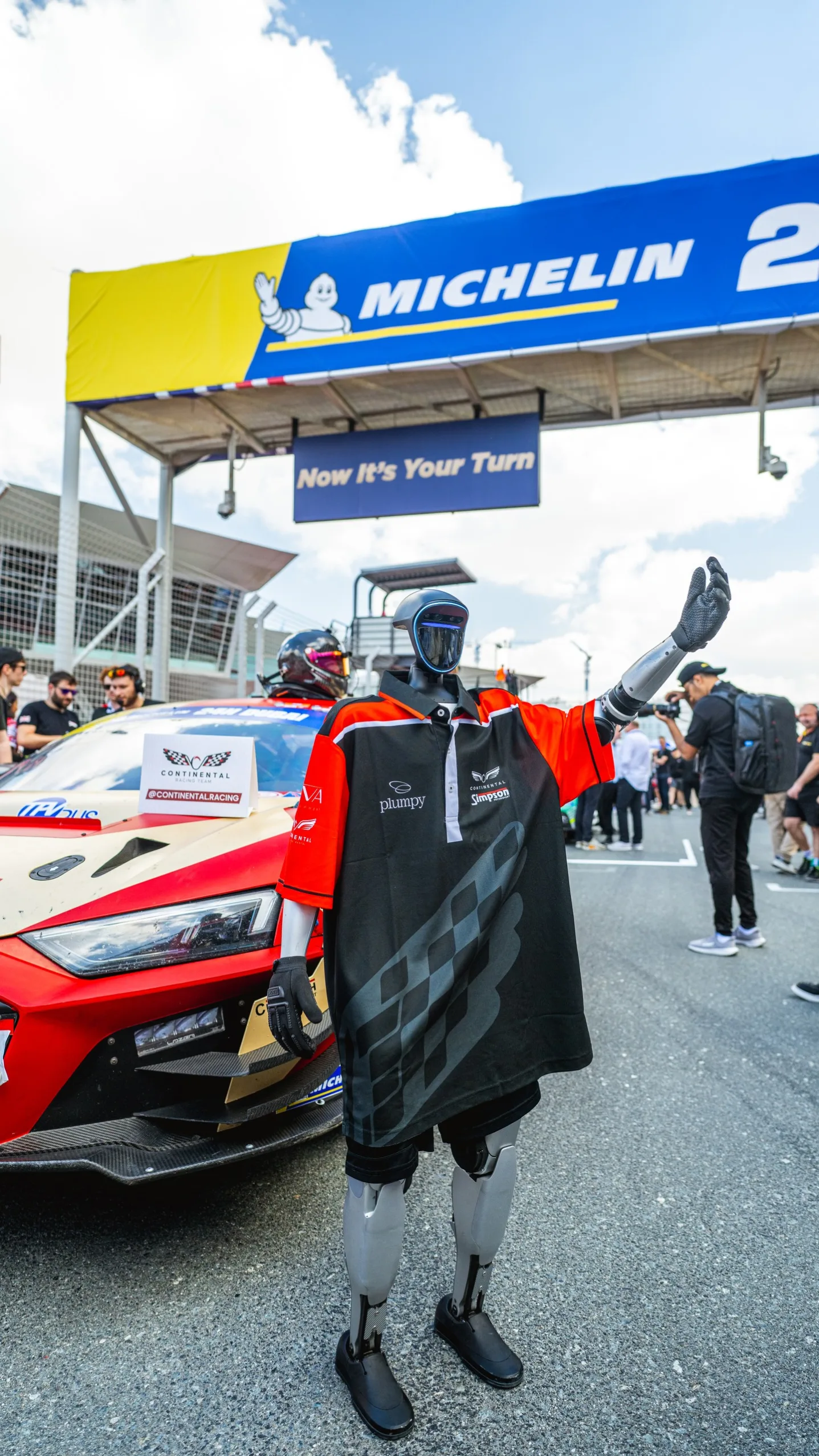 Fans gathering around the robot on the grid before the race